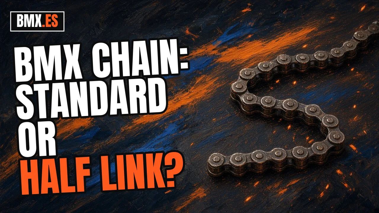 Loose BMX chain in an S shape on dark asphalt, with blue and orange brush strokes